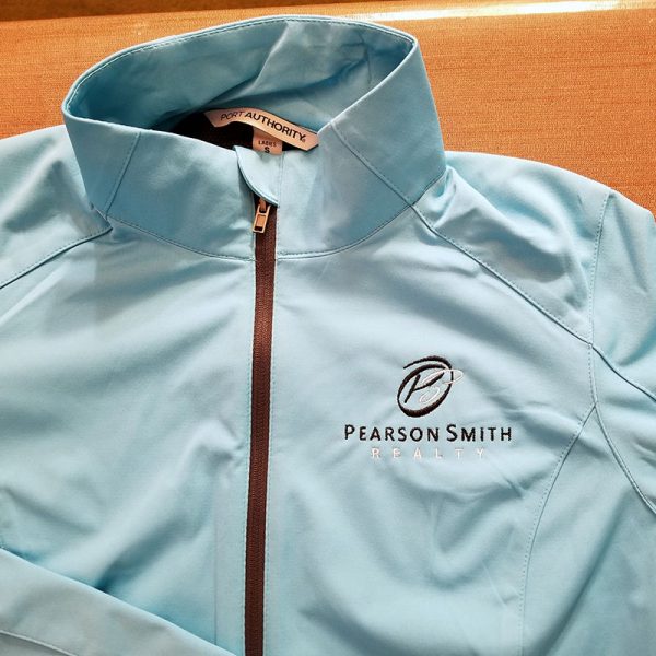 Closer view of jacket with Pearson Smith Realty logo embroidered on left chest