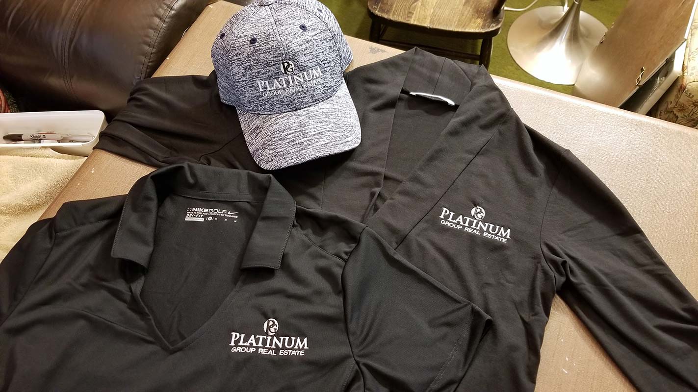 Polo, cardigan and baseball cap each embroidered with Platinum Group Real Estate logo
