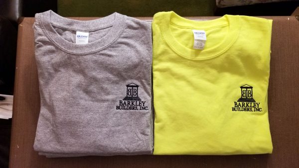Two t-shirts, one gray and one bright yellow, each with the logo for Barkley Builders embroidered in black on the left chest.