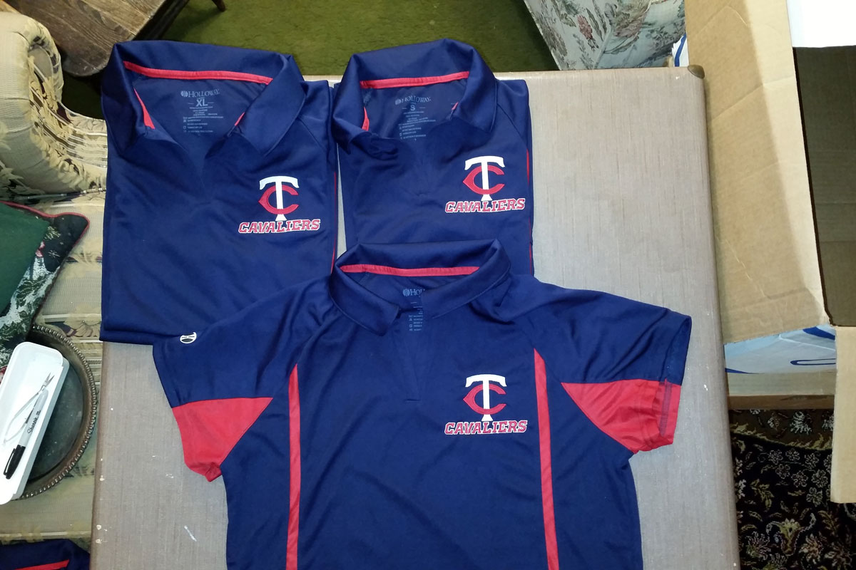 Set of blue and red athletic polos with a red and white TC logo and the word Cavaliers embroidered in red and white under the logo